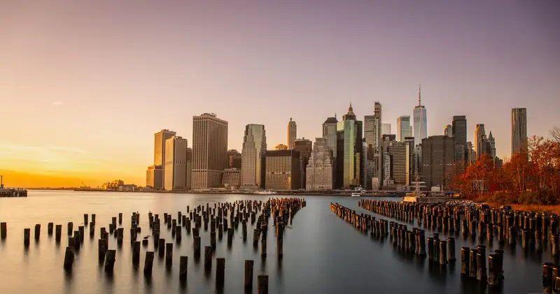 Manhattan at sunset, beyond the posts of an old pier. Photograph by Stefano Paolucci
